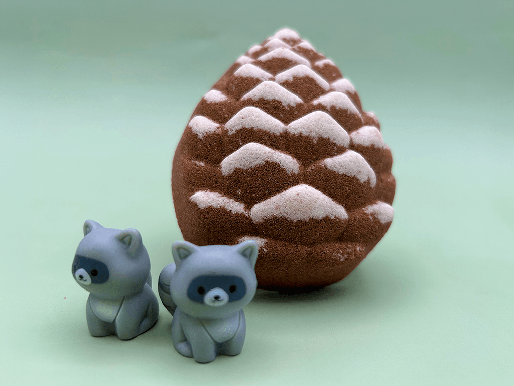 Snow Dusted Pine Cone Bath Bomb for Kids with Raccoon Figure Inside
